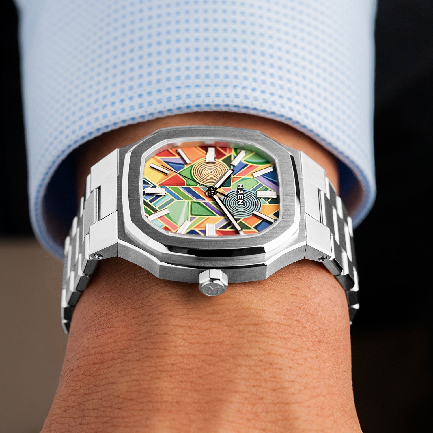 MAEN Manhattan Paradox — hand-painted geometric color-block dial with chevrons, mesh, and two concentric disks on a 37mm octagonal stainless steel case with integrated bracelet, limited edition timepiece by IFL Watches.