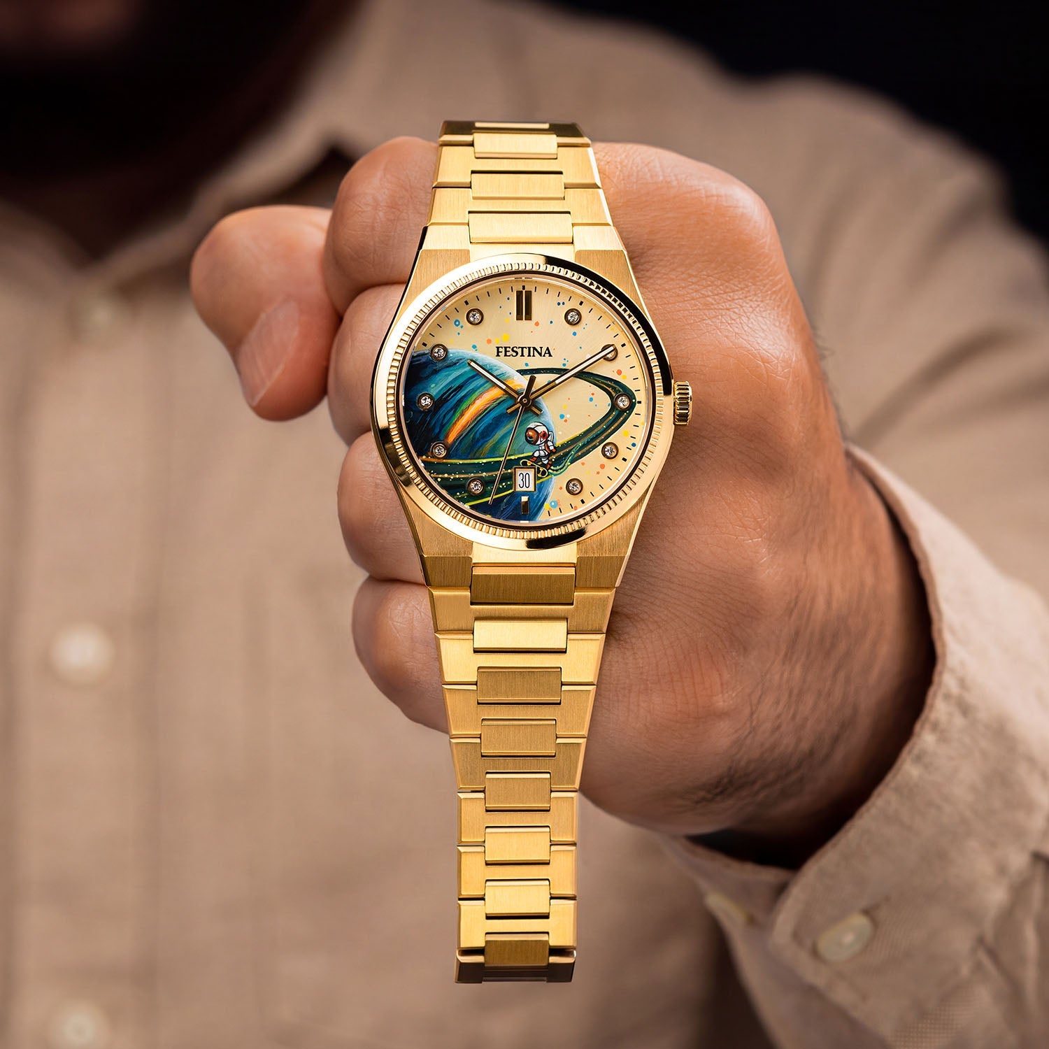 Festina Rive Space Ollie — Held in hand with the full gold bracelet visible, a hand-painted astronaut and ringed planet centered on the custom dial, customized by IFL Watches.