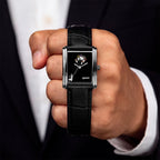 Laphont Bloc Bouquella — Held in a closed fist toward the camera, the hand-painted bouquets and the full length of the black croc-embossed strap in view, a limited edition bespoke timepiece by IFL Watches