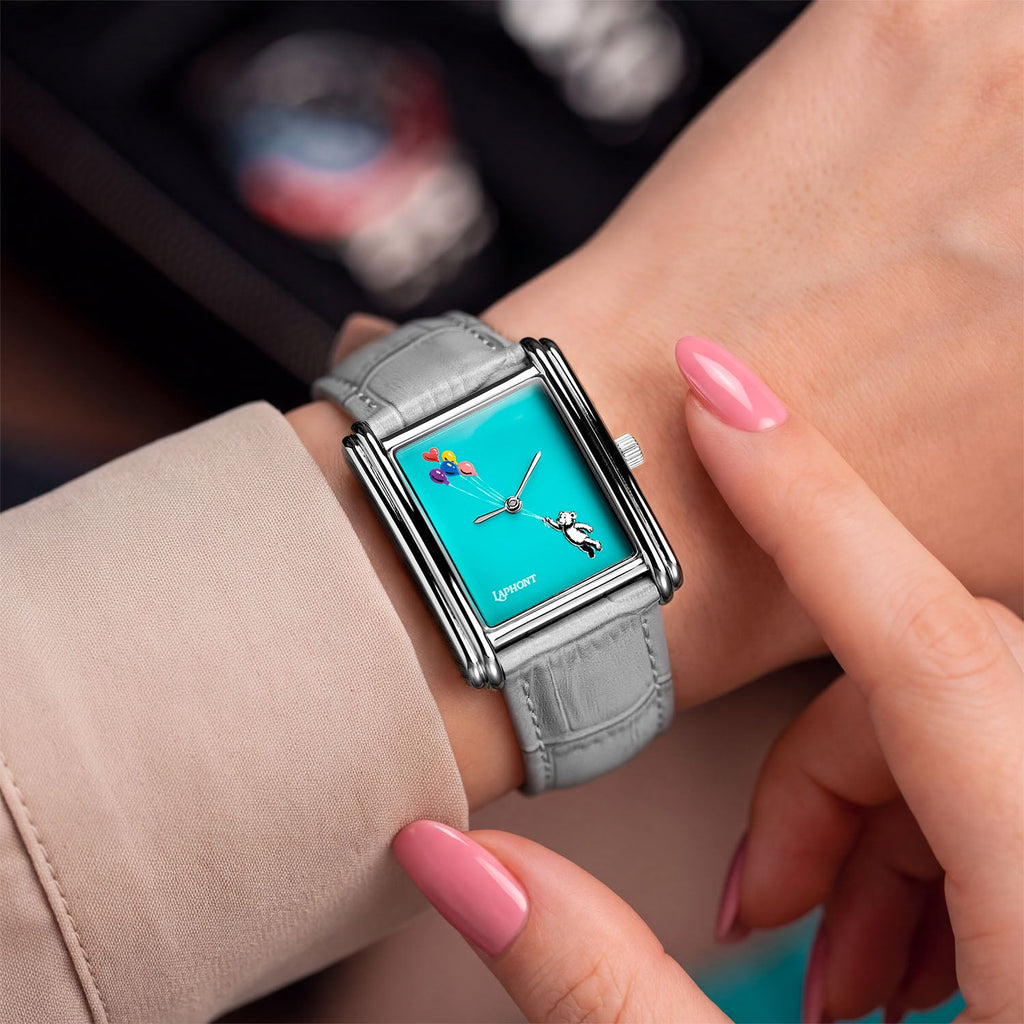 Laphont Bloc Cloudling — On a woman's wrist beneath a blush-beige sleeve, a pink-nailed fingertip resting by the crown beside the hand-painted bear and balloons, a custom limited edition timepiece by IFL Watches