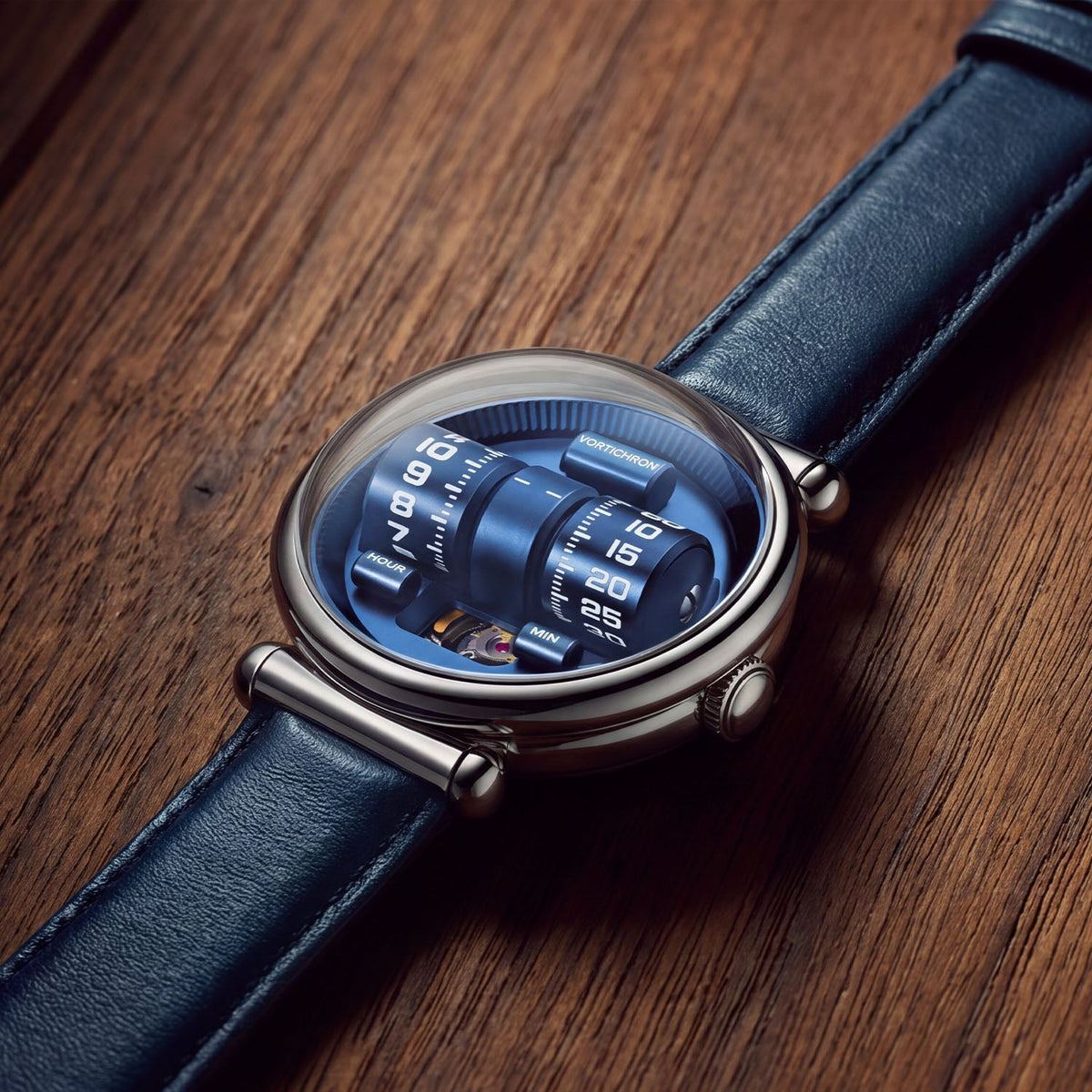 Vortichron Double Roller Blue — Lying on wood, seen from above with the rollers under the domed crystal, available at IFL Watches.