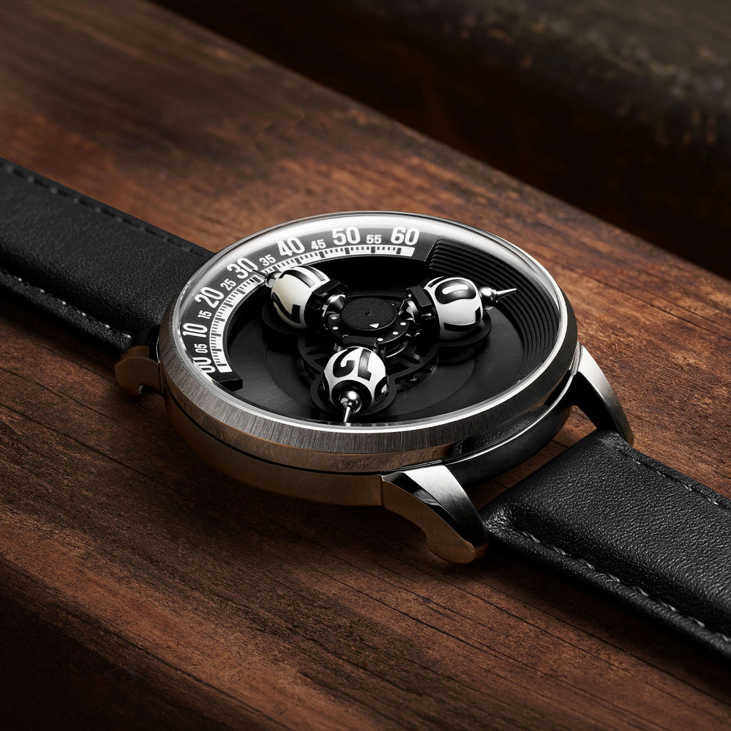 Vortichron Timeorb Midnight Black — Low side view on wood, showing the case profile and raised spheres under sapphire crystal, available at IFL Watches.