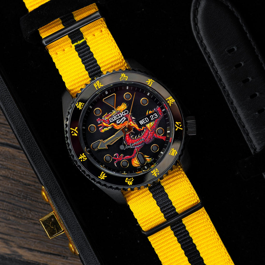 Custom Seiko 5 Sports 55th Anniversary Bruce Lee Limited Edition watch featuring hand-painted dragon design by IFL Watches, bespoke timepiece with black leather and yellow nylon straps.